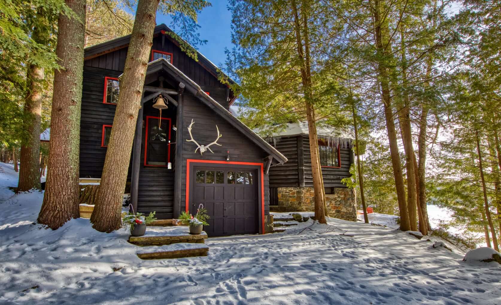 A lakefront Adirondack home in the early spring; snow is still on the ground, but the sky is sunny