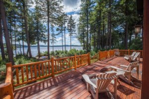 Adirondack reclining chairs are positioned on the beautiful wood porch to catch the warm afternoon sun